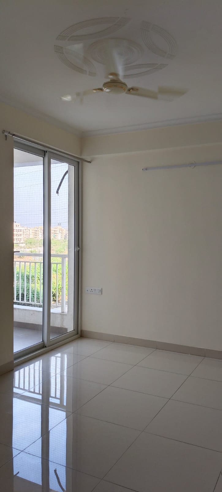 Room with balcony and clean reflective tile floor